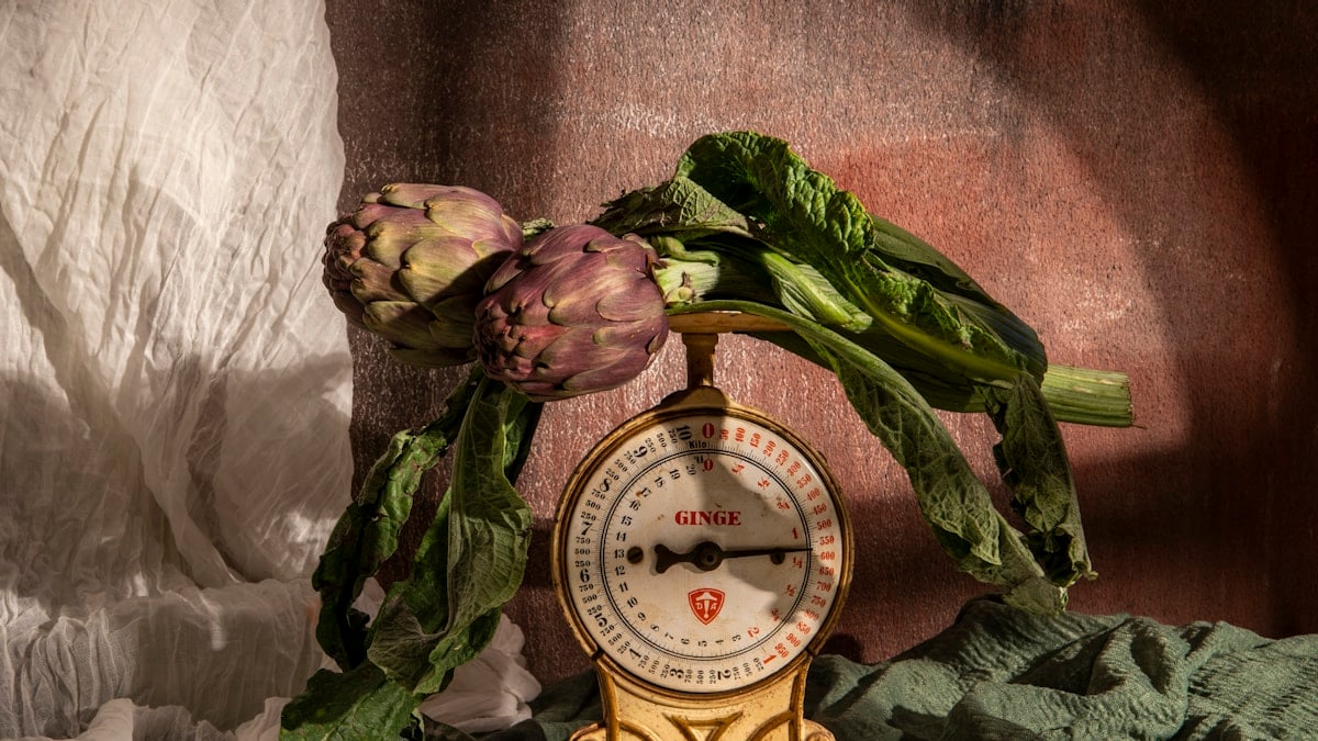 Artichokes rest upon an old-fashioned scale.