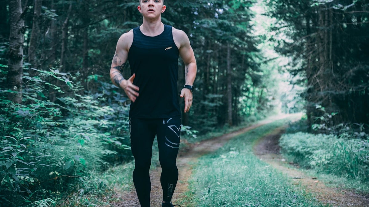 man walking on forest trail